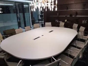 Стол для совещаний по индивидуальному заказу (столешница 360x250 см, цвет Белый шагрень W1000), оснащен двумя моторизированными блоками розеток и круглым пропуском для кабелей